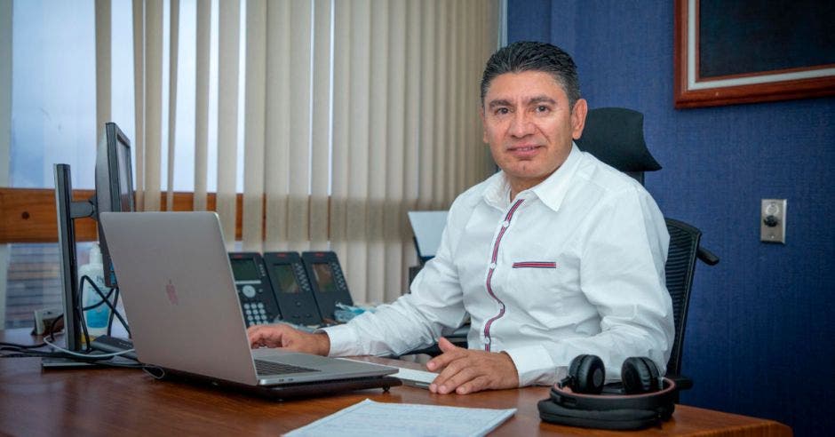 Hombre sentado en oficina frente a computadora