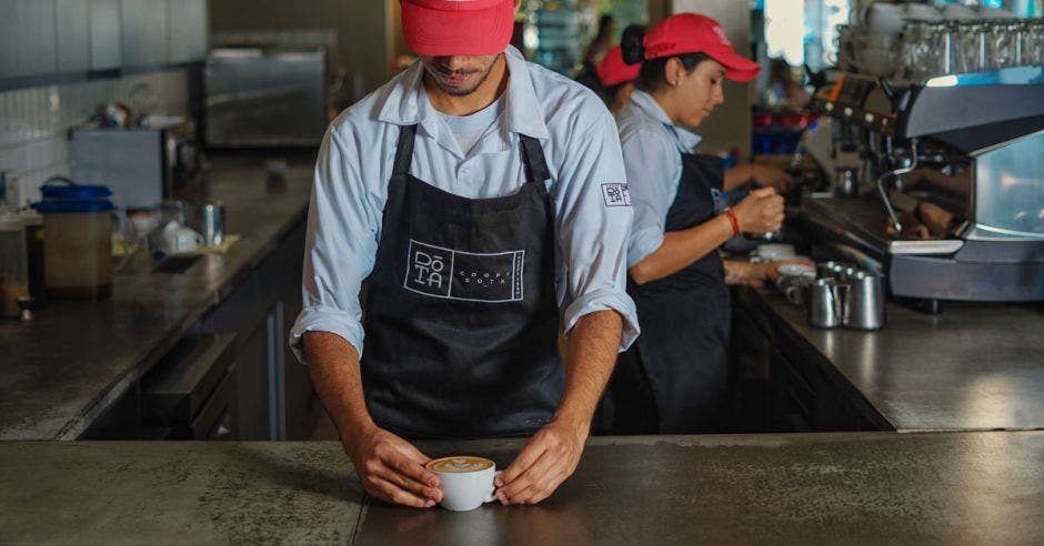 un hombre sirve café en una taza