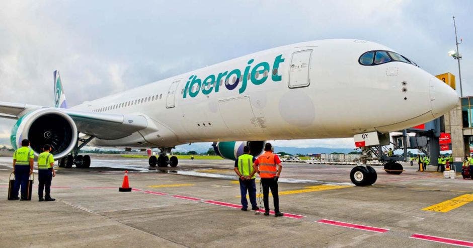 un avión color blanco de grandes dimensiones en una pista de aterizaje