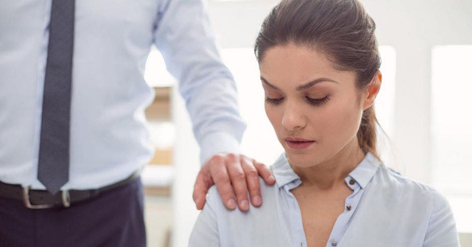 mujer incómoda al tener la mano de compañero sobre su hombro