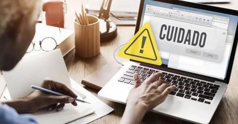 persona frente al computador con alerta de cuidado