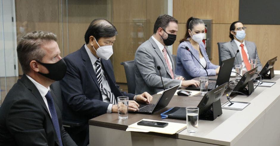 un grupo de hombres con saco y corbata discutiendo en un edificio