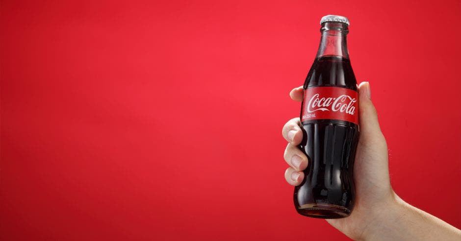 una mano sosteniendo una coca-cola