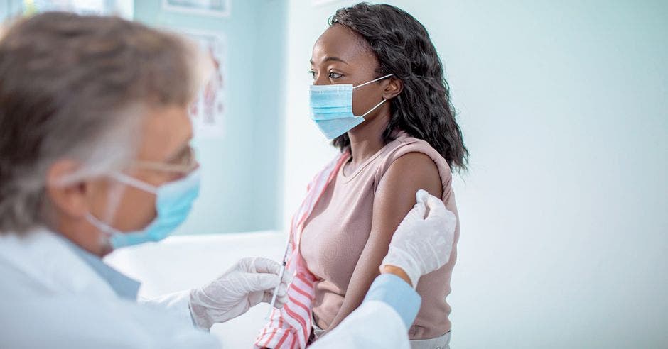 mujer afrodescendiente recibiendo vacuna de la influenza