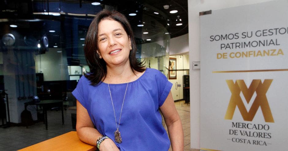 Mujer de azul frente a logo de Mercado de Valores