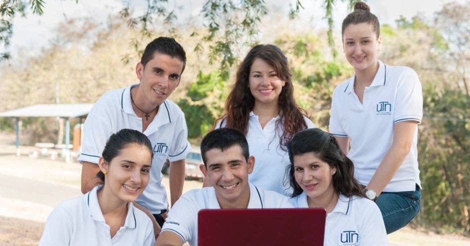 estudiantes en grupo frente a una computadora al aire libre