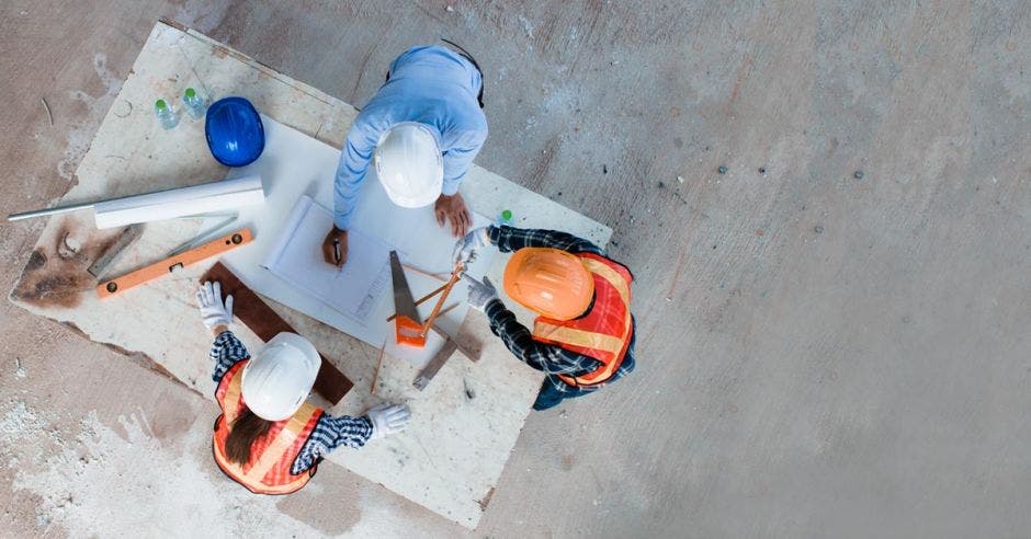 Grupo de tres arquitectos trabajando en el diseño de obra