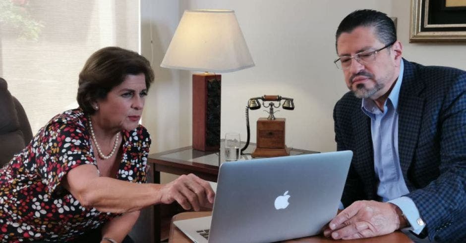 Pilar Cisneros y Rodrigo Chaves viendo laptop