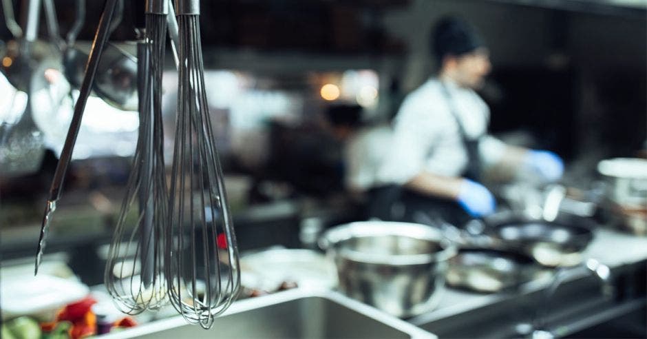 Utensilios de cocina en primer plano con chef de fondo