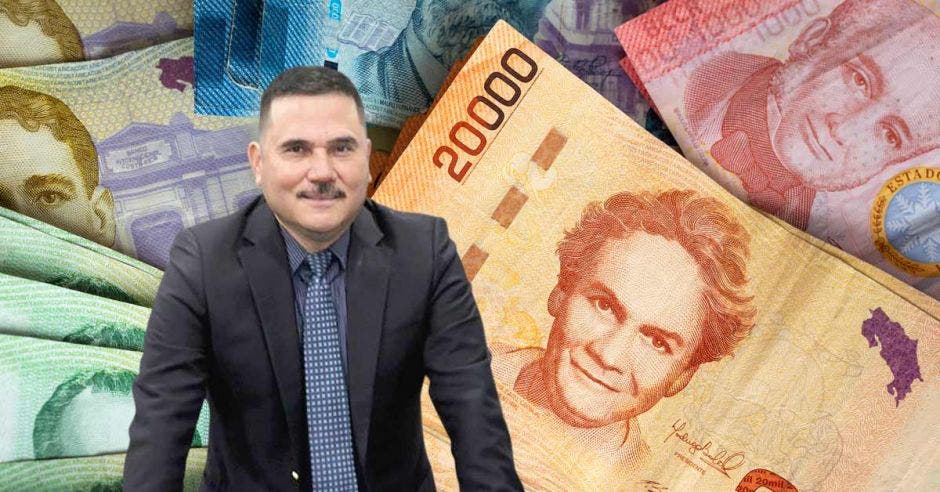 Hombre de traje frente a billetes ticos