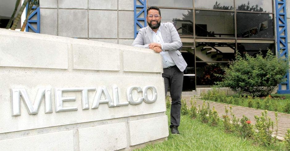 Jorge Luis Vega, gerente de Productos Planos de Metalco, detrás del rótulo con el nombre de la empresa, a la entrada de las instalaciones