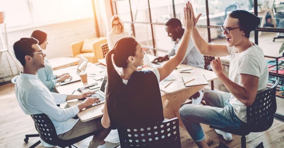 Cuatro trabajadores felices en la oficina