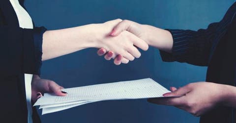 Mujeres con apretón de manos y contrato