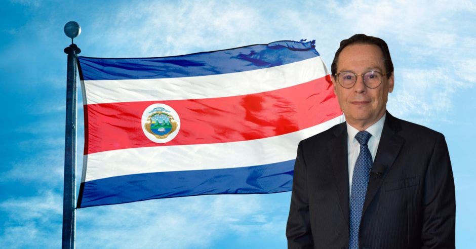 Hombre de traje frente a bandera