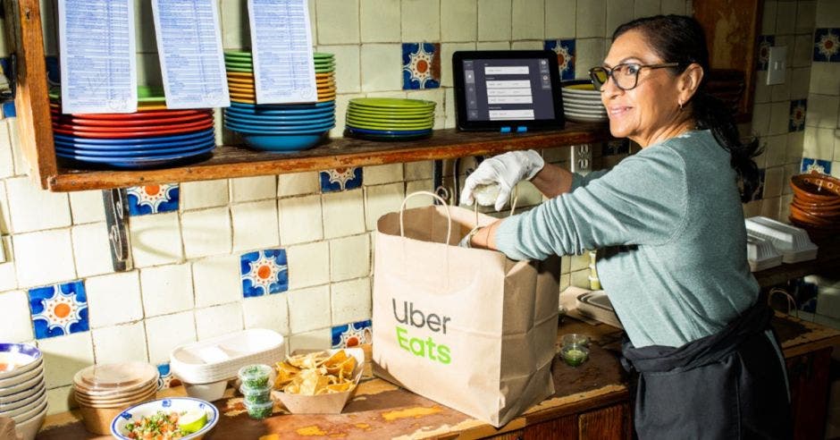 Mujer con paquetes de Uber Eats