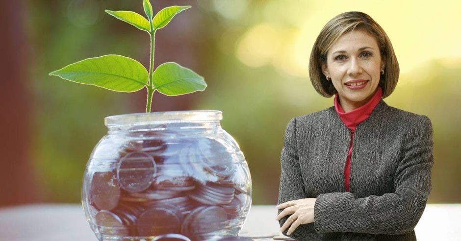 Mujer de traje frente a monedas y planta creciendo