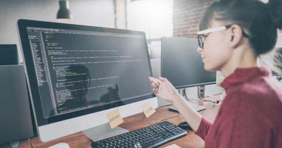 Mujer frente a computadora programando