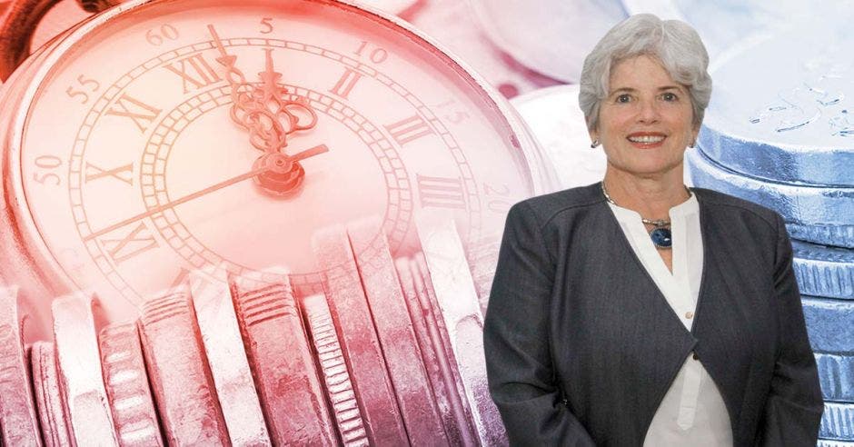 Mujer sonriente frente a monedas y reloj