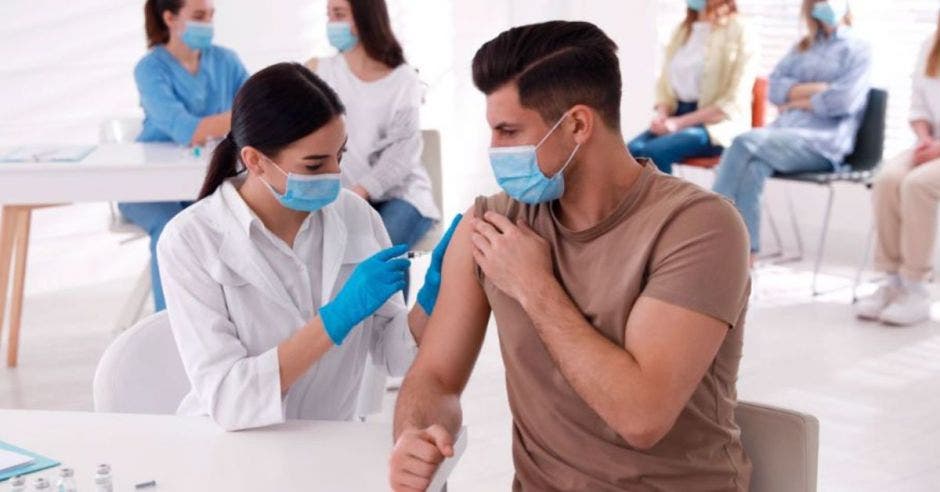 hombre siendo vacunado por una enfermera