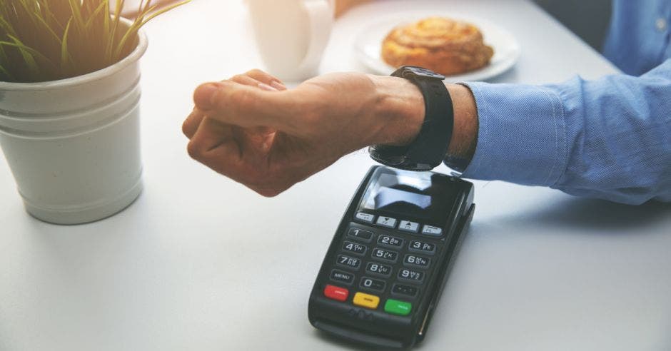 hombre pagando en un datáfono a través de su reloj inteligente