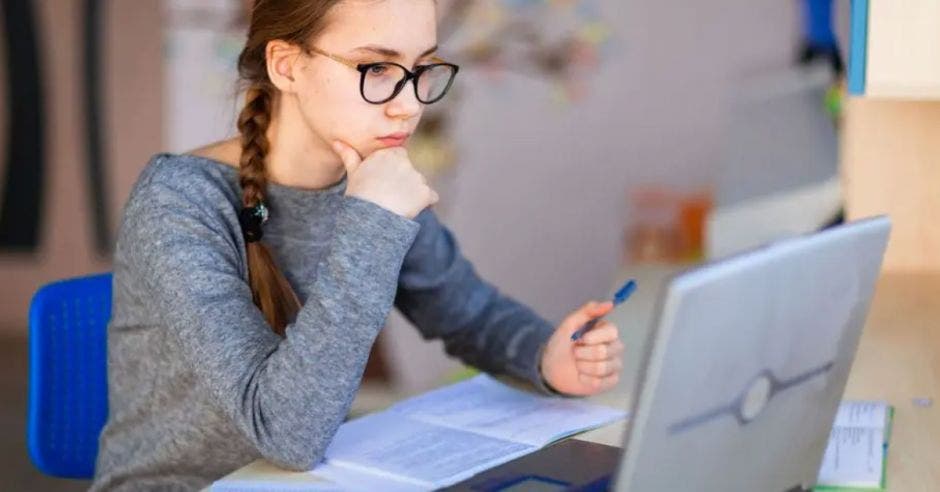 joven en frente de la computadora estudiando