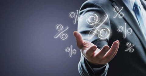 Una mano con varios signos de  porcentaje alrededor