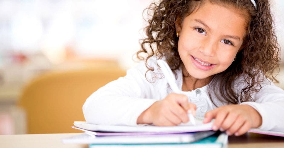 Niña con un cuaderno y un lápiz