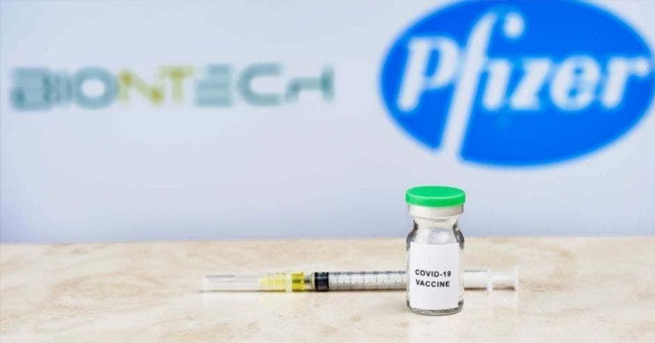 Una dosis de vacuna con un fondo que dice Pfizer