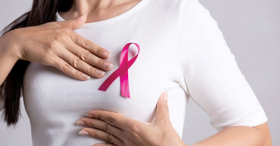 Mujer con blusa blanca y lazo rosado en conmemoración a la prevención del Cáncer de Mama