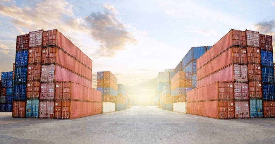 Una plataforma de contenedores en un puerto, con un atardecer de fondo