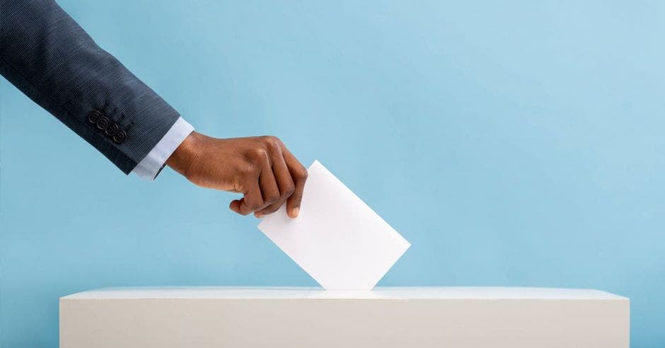 Un dibujo de una persona depositando el voto en una urna