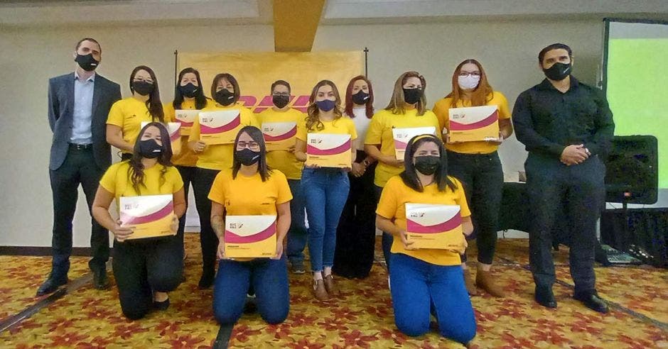 mujeres con playeras de DHL y diplomas