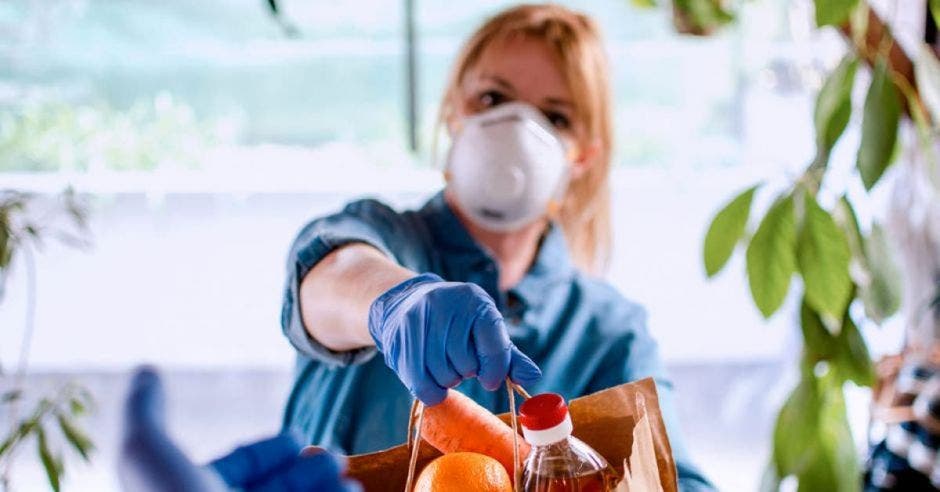 Mujer entregando bolsa con alimentos