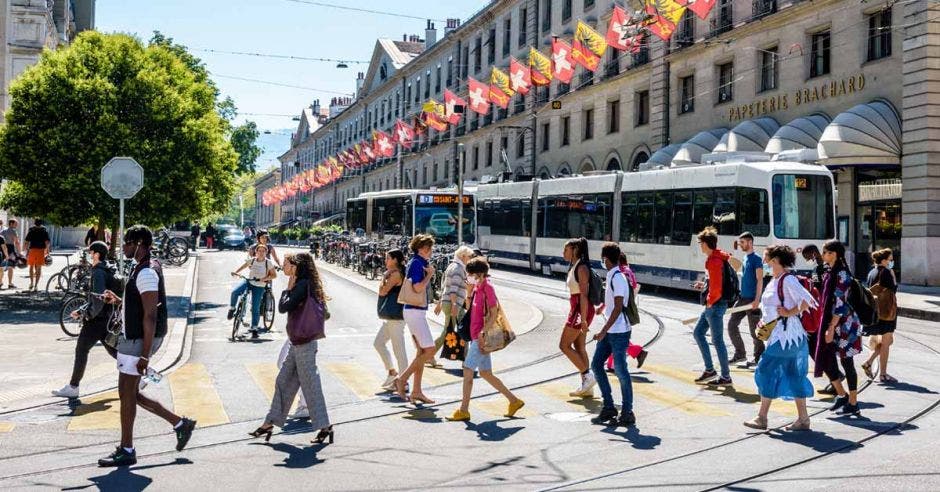 Una avenida con un tren eléctrico, peatones y ciclistas compartiendo el espacio