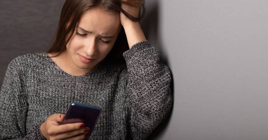 Mujer viendo el celular preocupada