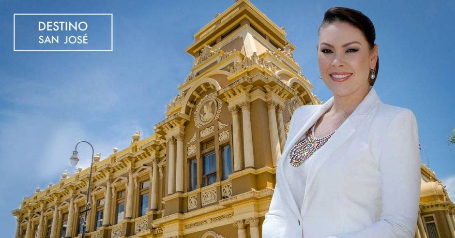 Mujer adulta con saco blanco, de fondo un edificio antiguo dorado