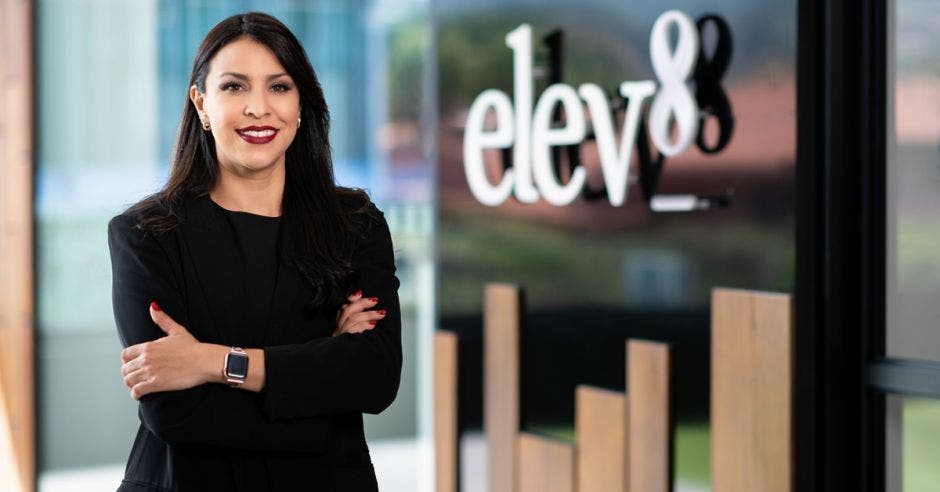 Mujer vestida de negro y al fondo las letras de elev8