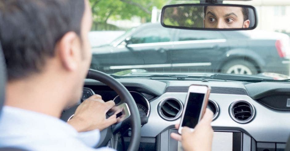 Hombre usando celular mientras maneja