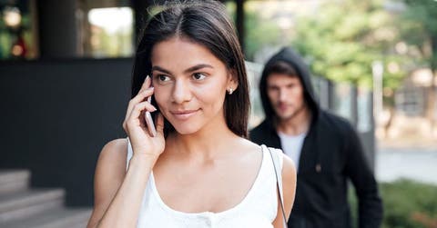 Hombre sigue a mujer que habla por celular