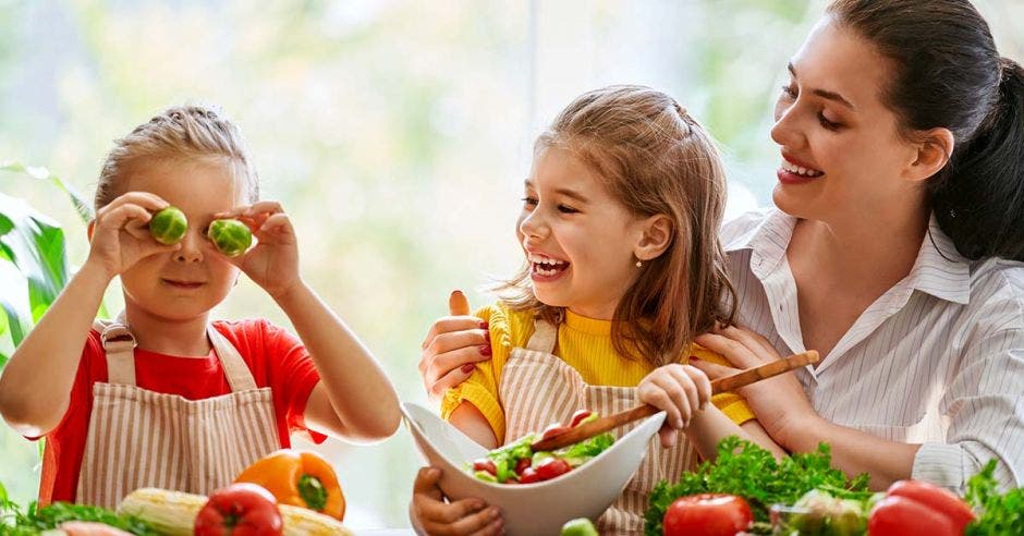 Mamá mostrándole comida saludable a sus hijas