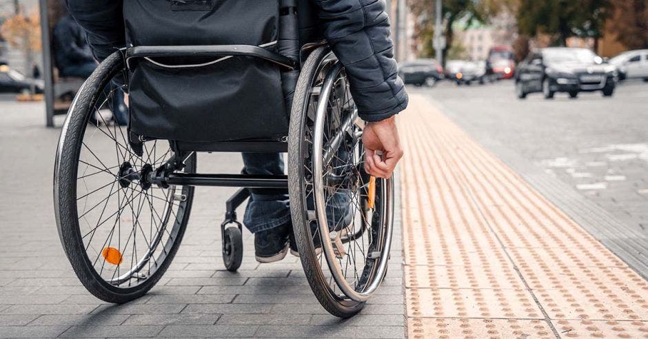 Persona en silla de rueda en una acera