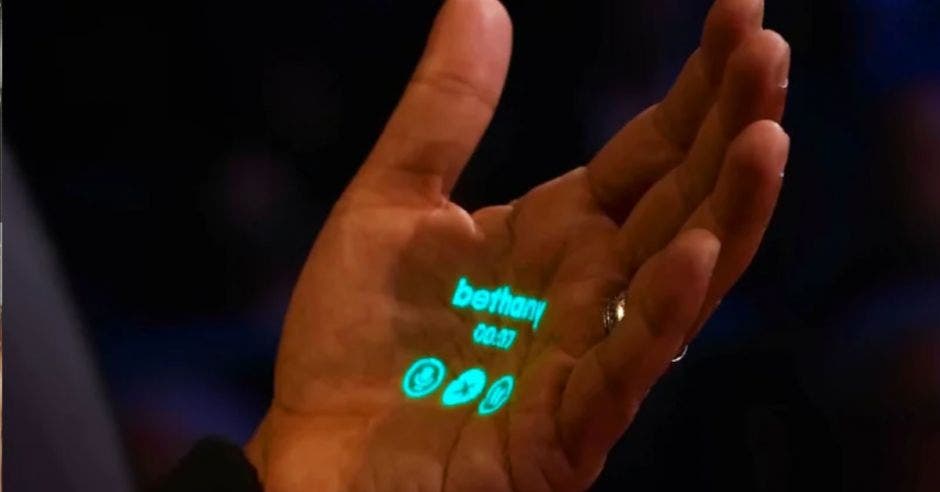 dispositivo tamaño dedo sensores parlantes integrados capaz proyectar palma mano pantalla smartphone se pueden hacer llamadas enviar mensajes utilizando comandos voz a partir tecnología IA