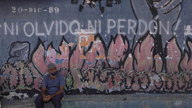 Un residente descansa frente a un mural alusivo a la invasión de Estados Unidos a Panamá de 1989 en el barrio de El Chorrillo, uno de los principales puntos destruidos durante la invasión, en la Ciudad de Panamá, capital de Panamá, el 25 de marzo de 2022. (Xinhua/Mauricio Valenzuela)