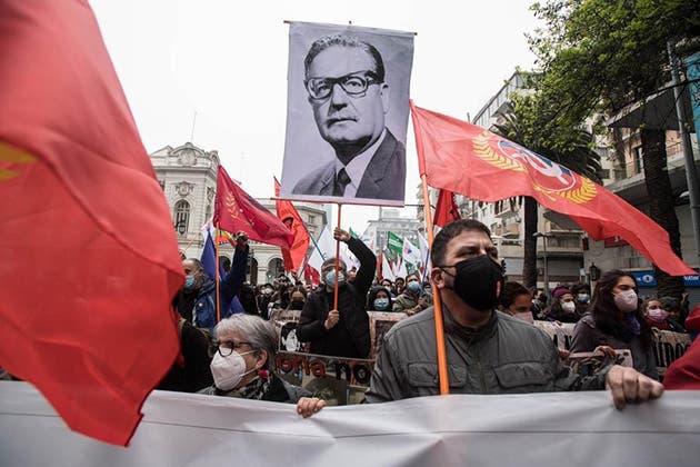 Personas sostienen banderas y un retrato del fallecido expresidente chileno, Salvador Allende, mientras participan en una marcha en el marco de la conmemoración del 48 aniversario del golpe de Estado del 11 de septiembre de 1973, en Santiago, capital de Chile, el 11 de septiembre de 2021. (Xinhua/Jorge Villegas)