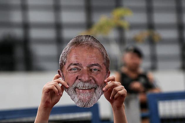 Una persona sostiene una máscara en una manifestación frente a la sede de la Policía Federal donde se encontraba detenido el entonces expresidente brasileño, Luiz Inácio Lula da Silva, en Curitiba, estado de Paraná, en el sur de Brasil, el 7 de abril de 2019. Simpatizantes de Lula se manifestaron frente a la prisión para conmemorar el primer aniversario de su arresto por corrupción y lavado de dinero, en el marco del caso Lava Jato. (Xinhua/Rahel Patrasso)