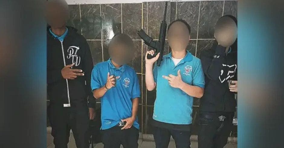 En la fotografía, uno de los jóvenes sostiene un fusil de asalto, otro muestra un revólver, un tercero porta una manopla de acero y un cuarto realiza poses con las manos. Cortesía/La República
